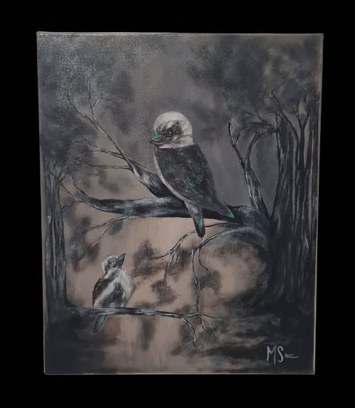 A square canvas painting of two kookaburras perched on branches in a dark, moody forest scene, displayed on a light gray wall.